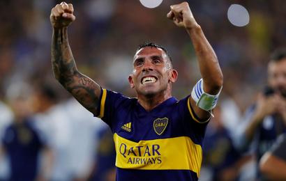 Boca Juniors captain Carlos Tevez raises his arms in celebration after clinching the Superliga title